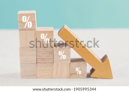 Wooden blocks with percentage sign and down arrow, financial recession crisis, interest rate decline, investment reduce, risk management concept