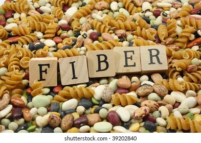 Wooden blocks spelling out the word FIBER with a background of high fiber foods.