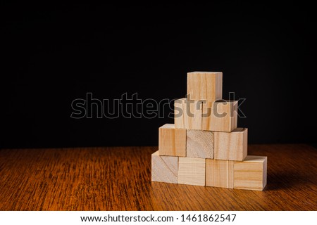 Wooden blocks stacked against black background