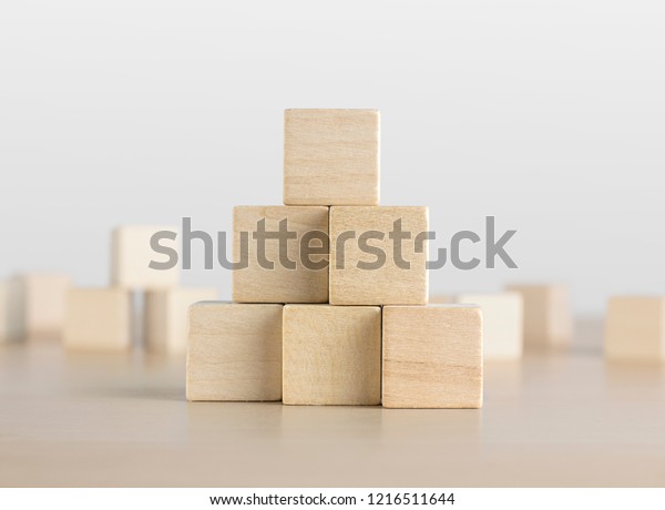 Wooden blocks stacking as a pyramid staircase on\
white background. Success, growth, win, victory, development or top\
ranking concept.