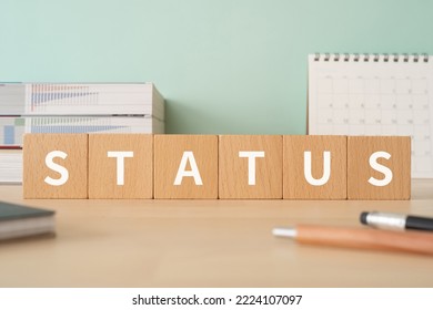 Wooden blocks with "STATUS" text of concept, pens, notebooks, and books. - Shutterstock ID 2224107097