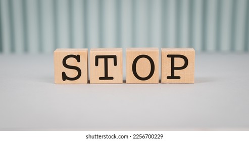 Wooden blocks with STOP text of concept, grey background. - Shutterstock ID 2256700229