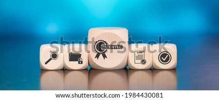 Wooden blocks with symbol of patent concept on blue background