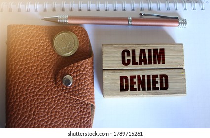 Wooden Blocks with the text: Claim Denied, brown leather wallet, pen and coins. Insurance Business concept. - Shutterstock ID 1789715261