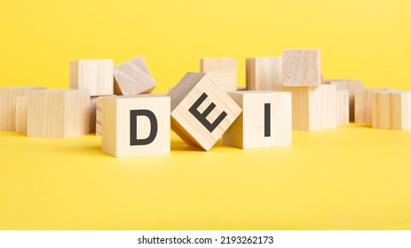 Wooden Blocks With Text DEI On Yellow Background. Dei - Short For Diversity Equity Inclusion