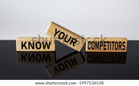 Wooden blocks with the text KNOW YOUR COMPETITORS on a white and black background.