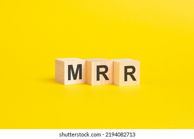 Wooden Blocks With Text MRR - Monthly Recurring Revenue - On Yellow Paper, Business Concept