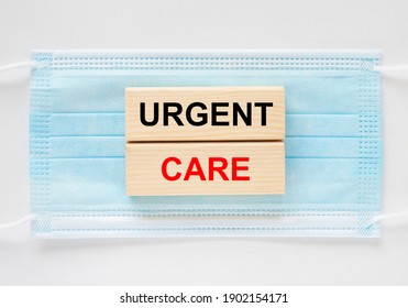 Wooden Blocks With Text Urgent Care Lying On The Mask. Medical Concept