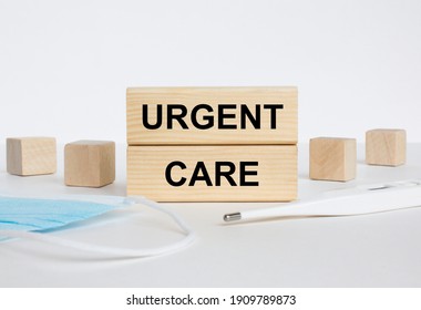 Wooden Blocks With Text Urgent Care With Mask And Thermometer. Medical Concept