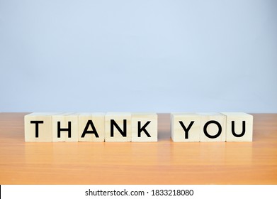 Wooden blocks with THANK YOU lettering on blurred background with copy space. 
					