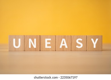 Wooden blocks with "UNEASY" text of concept. - Shutterstock ID 2235067197