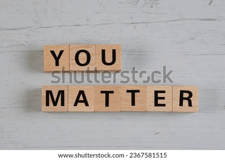 wooden blocks  in a white and grey board with the text you matter