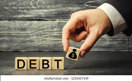Wooden blocks with the word debt and the image of dollars. Payment of taxes and of debt to the state. Concept of financial crisis and problems. Risk management. Debt exemption. loan