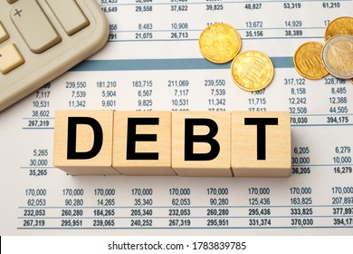 Wooden blocks with the word Debt. Reduction or restructuring of debt. Refusal to pay debts or loans and invalidate them