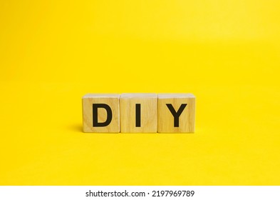 Wooden Blocks With The Word DIY - Do It Yourself Concept. The Method Of Self-creation Of Things Without The Help Of Professionals. Yellow Background