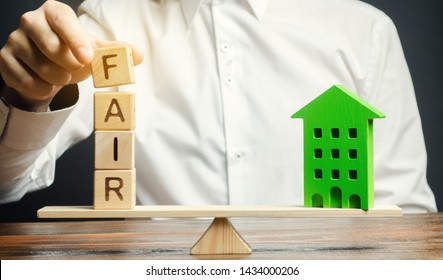 Wooden blocks with the word Fair and a wooden house. Fair value of real estate and housing. Property valuation. Home appraisal. Housing evaluator. Legal transparent deal. Apartment purchase / sale.