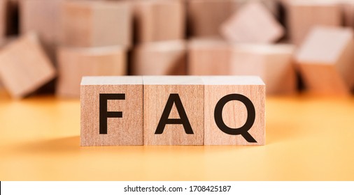 Wooden blocks with word FAQ on yellow baclground. Frequently asked question concept