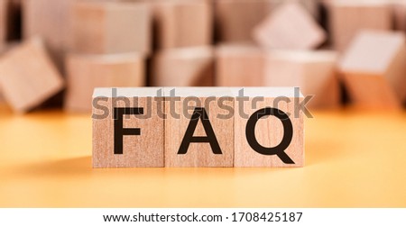 Wooden blocks with word FAQ on yellow baclground. Frequently asked question concept