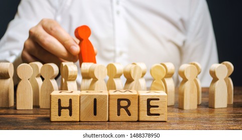 Wooden blocks with the word Hire. Headhunter selects a person from the crowd. Human Resource Management. Recruiting Headhunting. Hiring employees. Businessman points to the red man. Recruit - Shutterstock ID 1488378950