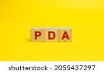 Wooden blocks with the word PDA. Personal Digital Assistant acronym concept. Technology, business and finance