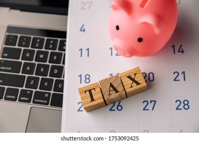 Holzblöcke mit dem Wort TAX und Sparschwein. Steuerplanung, Steuererstattung oder Steuerkonzept.