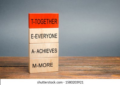Wooden blocks with the word Together, Everyone, Achieves, More. Teamwork and team concept. Community, support, partnership. Achieving a common goal. Cooperation and business strategy