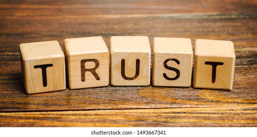Wooden blocks with the word Trust. Trust relationships between business partners, friends, relatives. Respect and authority. Confidence in a person. Reliable partner