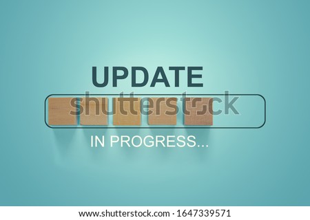 Wooden blocks with the word UPDATE  in loading bar progress.
Business concept for act updating something someone or updated version program.