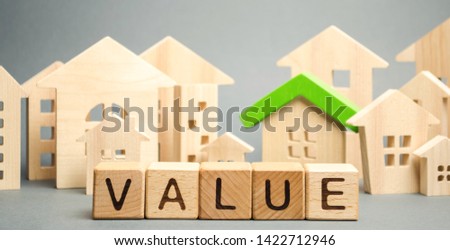 Wooden blocks with the word Value and wooden houses. Property valuation and housing. The best value of the apartment or house for sale. Home appraisal. Real estate market. Mortgage rates