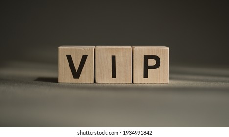 A Wooden Blocks With The Word VIP Written On It On A Gray Background.