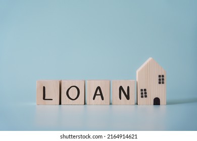 Wooden Blocks Wording Loan And Small House Model Concept Of Loan And Mortage For Real Estate. Buy House With Agent Or Bank.