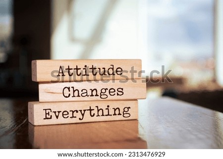 Wooden blocks with words 'Attitude Changes Everything'.