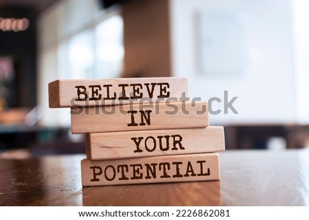 Wooden blocks with words 'Believe in your potential'.