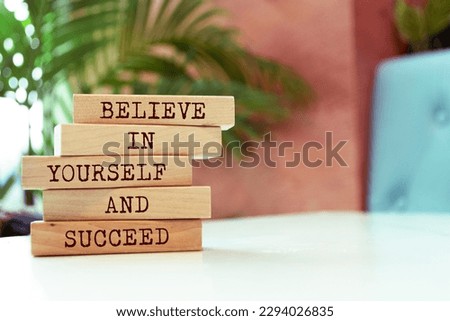 Wooden blocks with words 'Believe in yourself and succeed'.