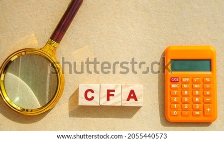 Wooden blocks with the words CFA - Chartered Financial Analyst. Postgraduate professional certification. Business, investment and finance concept