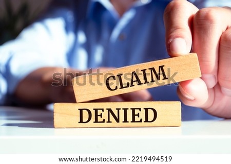 Wooden blocks with words 'Claim denied'.