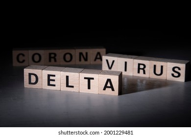 Wooden Blocks With The Words Delta, Corona And Virus. Symbol For Variant Delta