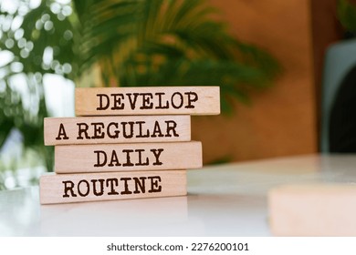 Wooden blocks with words 'Develop a regular daily routine'.