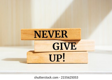 Wooden blocks and words 'NEVER GIVE UP' 