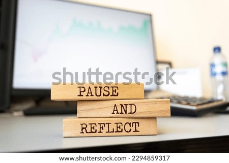 Wooden blocks with words 'PAUSE AND REFLECT'. Business concept