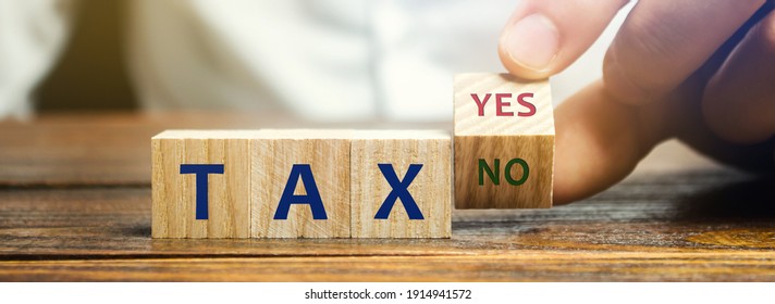 Wooden blocks with the words Tax, yes or no. Taxes payment concept. Tax evasion. Taxation. Business and finance. Choose, make a choice