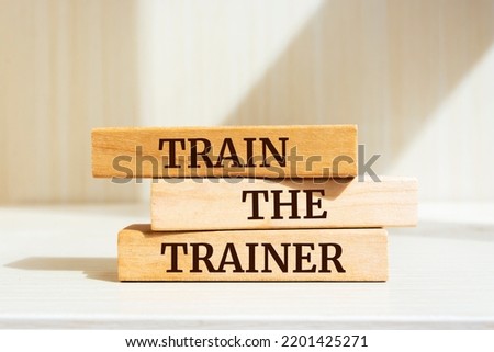 Wooden blocks with words 'Train The Trainer'.