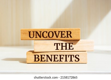 Wooden blocks with words 'Uncover The Benefits'.