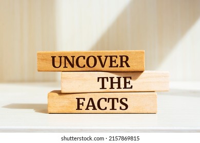 Wooden blocks with words 'UNCOVER THE FACTS'.