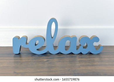 wooden blue relax inscription on a white rug - Powered by Shutterstock