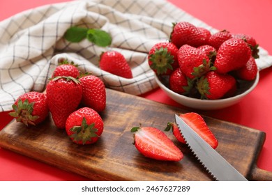 Wooden board and bowl with sweet fresh strawberries on red background - Powered by Shutterstock