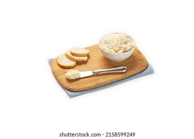 A Wooden Board With A Cream Cheese, A Knife And Bread Pieces Isolated On A White Background