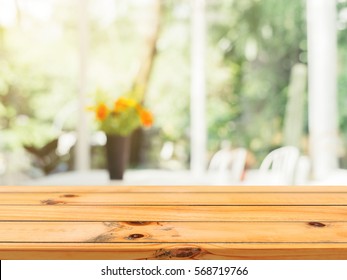 Wooden Board Empty Table Blurred Background. Perspective Brown Wood Over Blur Flower Vase In Coffee Shop - Can Be Used For Display Or Montage Your Products.Mock Up For Display Of Product.