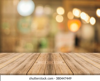 Wooden Board Empty Table In Front Of Blurred Background. Perspective Brown Wood Over Blur In Coffee Shop - Can Be Used For Display Or Montage Your Products.Mock Up For Display Of Product.