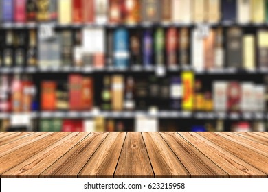 Wooden board empty table in front of blurred background. Perspective alcohol bottle on Shelf in Supermarket can be used for display or montage your products - Powered by Shutterstock